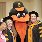 Party attendees pose for photos with the Orioles mascot.