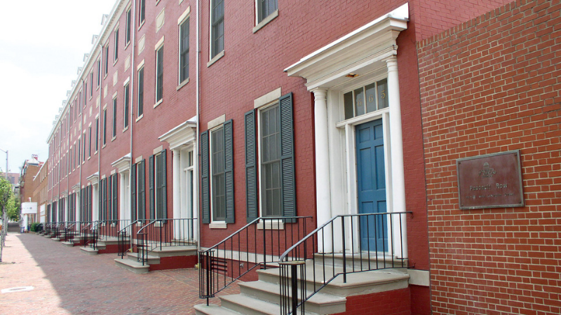 Row of brick rowhouses with shutters and white doorway molding