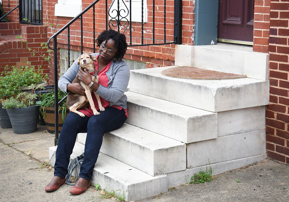 Khandra Sears and her dog on the porch of their Union Square home