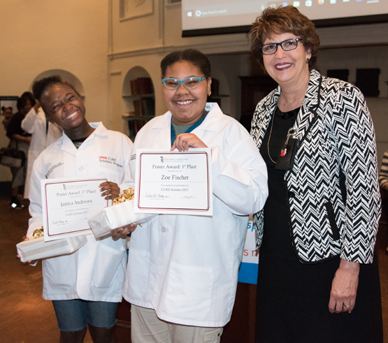 CURE Scholars Janiya Andrews, left, and Zoe Fisher hold first-place certificates awarded by Karen Faraone, DDS, MS, assistant dean of student affairs at the University of Maryland School of Dentistry and judge of the public health poster contest. 