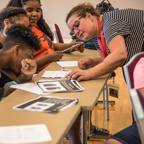 Ann Felauer, MSN, RN, CPNP-AC/PC, clinical instructor at the University of Maryland School of Nursing, engages eighth-grade CURE Scholars during the mathematical portion of a forensics lab.