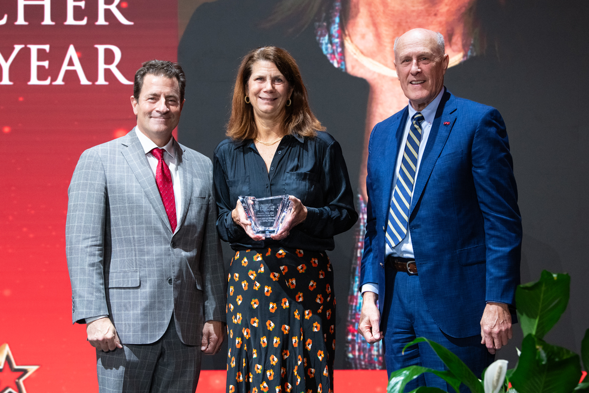 UMB Researcher of the Year Kathleen Neuzil is flanked by School of Medicine Dean Mark Gladwin (left) and UMB President Bruce Jarrell.