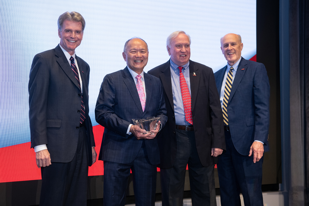 Henry Lee (second from left) is joined by (from left) UMSOD Dean Mark Reynolds, UMB Foundation Board of Trustees Chair Harry Knipp, and UMB President Bruce Jarrell after receiving the Distinguished Service Award.