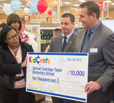 Principal Bettye M. Adams of The Historic Samuel Coleridge-Taylor Elementary School, which is among Promise Heights' Community Schools, accepts a donation. Rite Aid Executive Vice President of Operations Bryan Everett, right, is shown with Baltimore City Councilman Eric Costello, center, and Catherine Pugh, state senator (40th District), behind Adams.