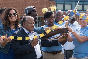 Baltimore City Councilman William “Pete” Welch joins volunteers and Harlem Park Principal Denisha Logan in a ribbon-cutting ceremony.