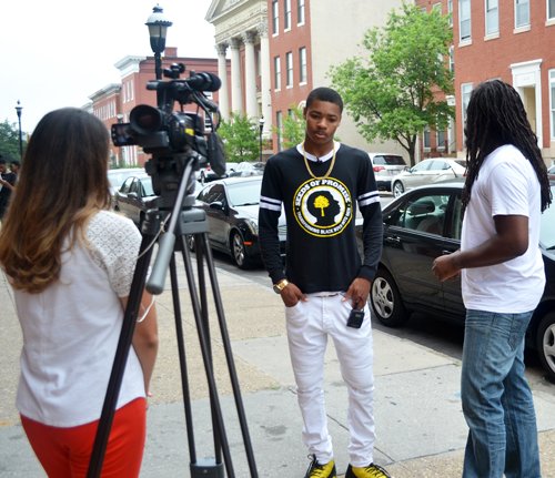 Khalil Bridges and Antwon Cooper of the Seeds of Promise mentoring program, right, are interviewed by WMAR-TV reporter Mallory Sofastaii outside Renaissance Academy, which is among the University of Maryland School of Social Work community schools.