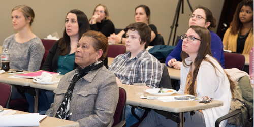 Cynthia Rice, director of student development and leadership,(first row), and students listen to Michael Reisch, PhD, MSW, MA, speaks about 