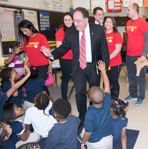 UMB President Jay A. Perman, MD, greets kindergartners participating in an after-school wellness program at Furman L. Templeton Preparatory Academy. Students from UMB (shown in red shirts) have been trained as 