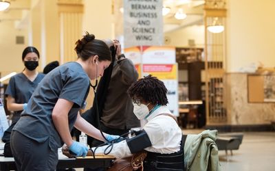 University of Maryland School of Nursing student Annika Marquez checks the blood pressure of an Enoch Pratt Library patron at the Central Library location.