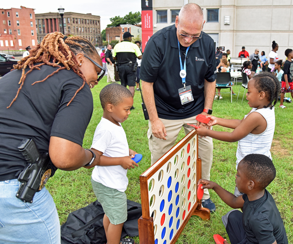 Cpl. Hazel Lewis and Cpl. J.R. Jones play outdoor games with several West Baltimore neighbors. 
