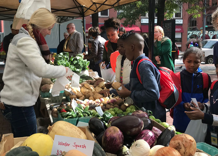 The Kids to Farmers Market program is a hands-on learning experience for West Baltimore third-graders. The program brings the children to a local farmers market to buy local produce and learn about nutrition and healthy eating habits.