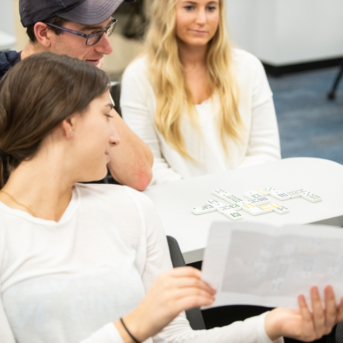 Students review the results of their domino exercise during a Foundations of IPE (interprofessional education) course aimed at teaching communication skills in team-based care.