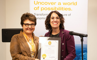 Marianne Navarro (right), representing the Mayor’s Office of Neighborhood Development, presents Illumina vice president of Americas service and support Eleezeh Safarians with a citation on behalf of Mayor Jack Young. 