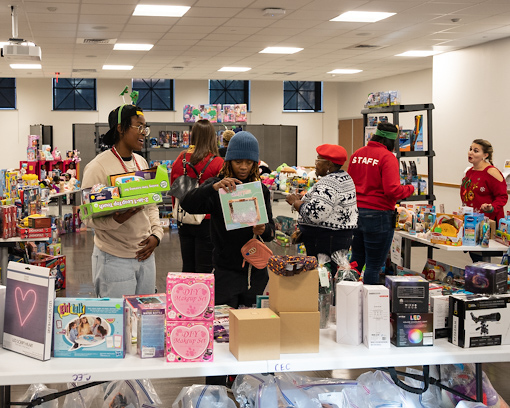 West Baltimore neighbors browse the toy selection at the annual Christmas Store, set up in UMB's Community Engagement Center.