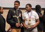 Khamari Stubbs (left), a Cohort 4 CURE Scholar, and Jaylen Galmore, a Cohort 3 CURE Scholar, accept their trophies for coming in first place at the 2019 CURE STEM Expo in the anatomy curriculum category.