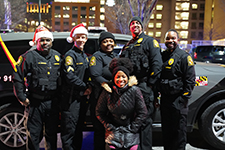 UMBPD Officers in Santa hats in front of a patrol vehicle