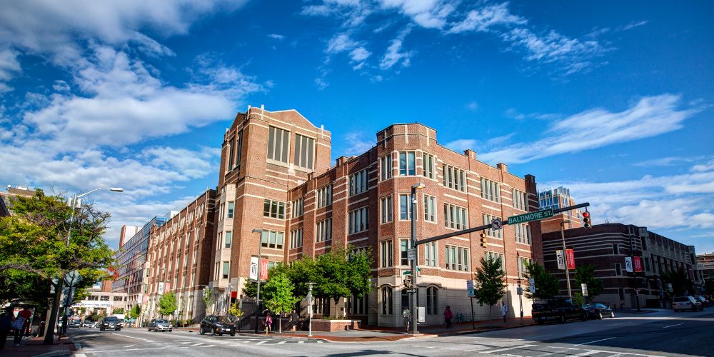 The Maryland Carey Law School building on a bright sunny day with a few white clouds visible against a very blue sky