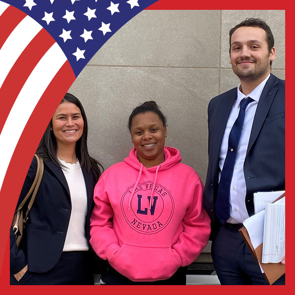 Two Maryland Carey Law students with a client, standing outside of a courthouse