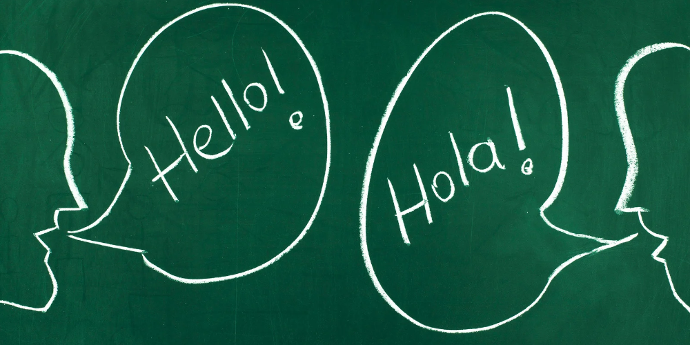 Chalkboard drawing of people saying "Hello!" and "Hola!"