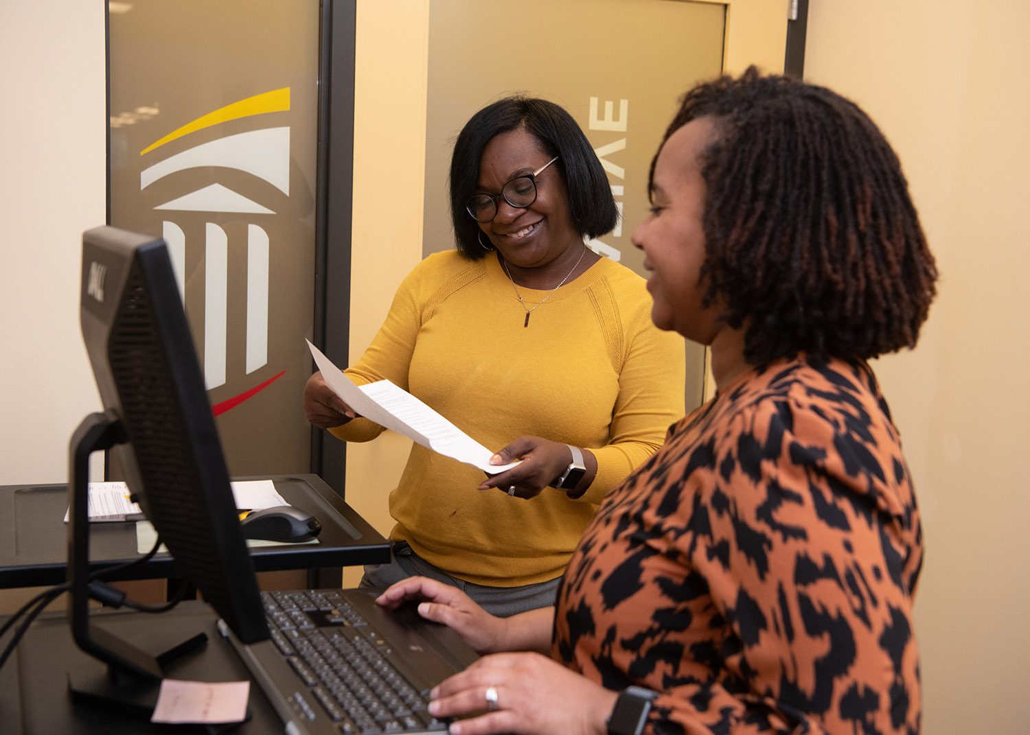 two professionals collaborate at a computer