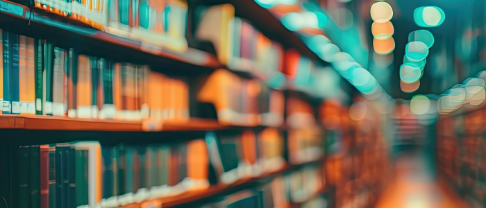 blurred background of books and bookshelves in library hallway