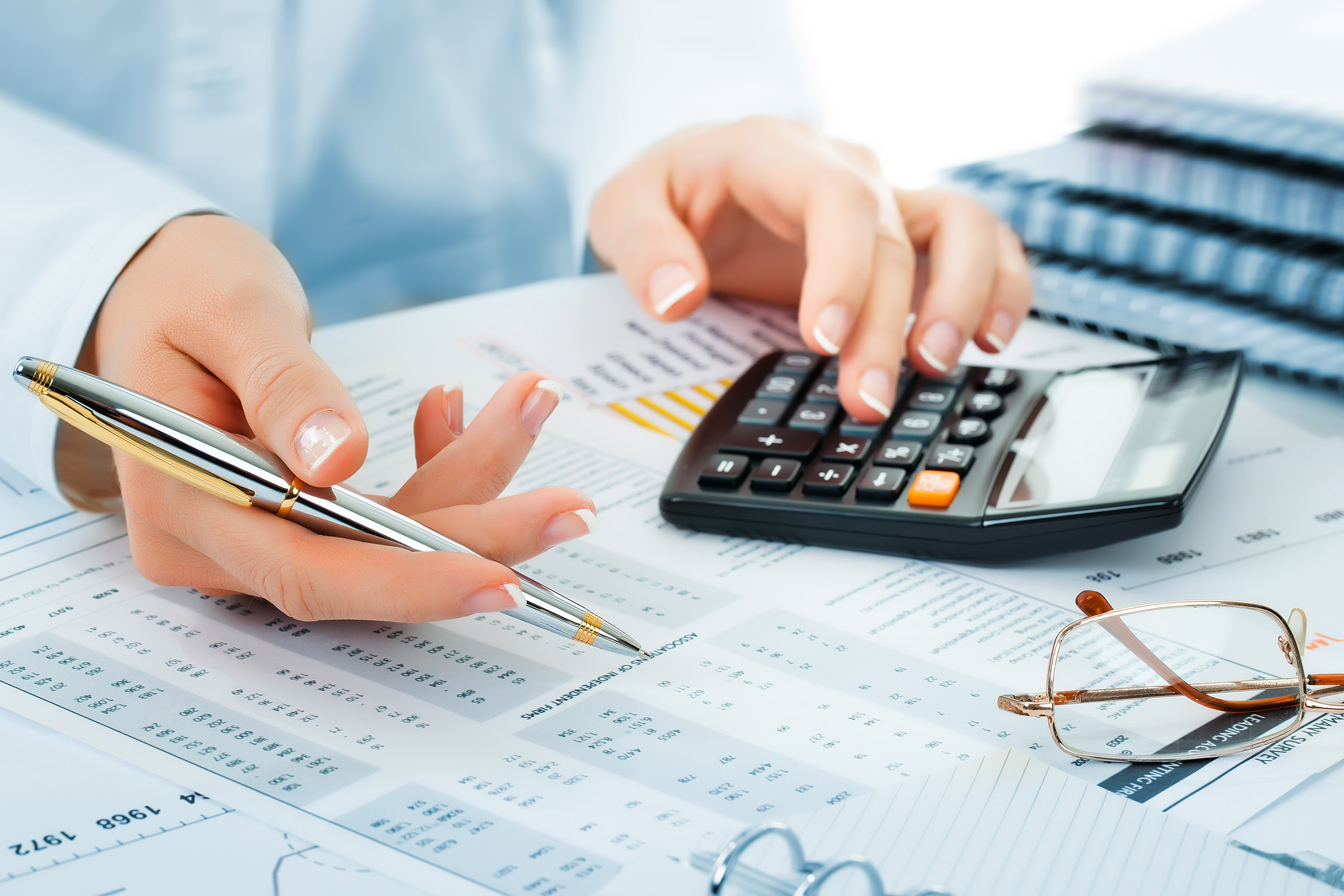 A person uses a calculator to review financial documents.