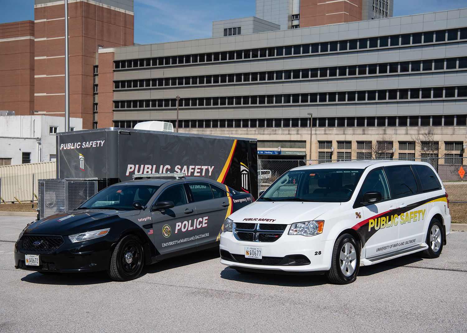 University safety vehicles including a police car, public safety van and trailer