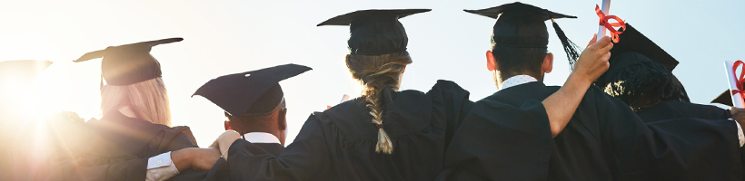 Students celebrating in graduation gowns