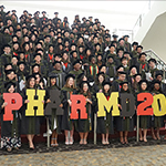 School of pharmacy students hold up signs in celebration of graduation