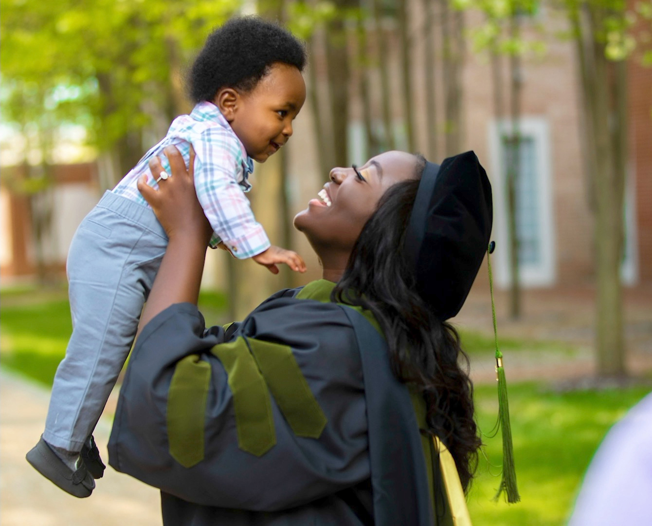 A School of Pharmacy graduate celebrates and holds their child