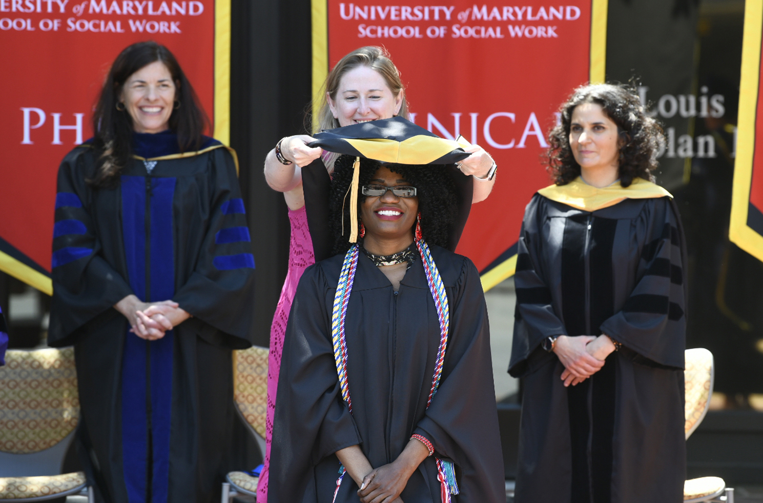 Social Work graduate at an outdoor hooding ceremony