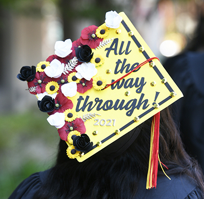 A graduate with a decorated cap that says 