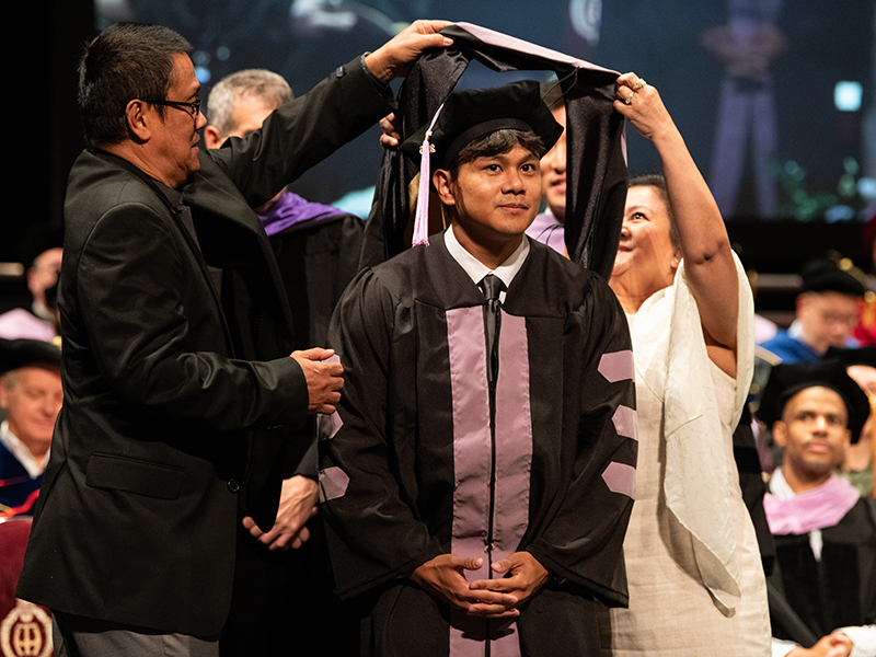 UMB School of Dentistry graduate being hooded.