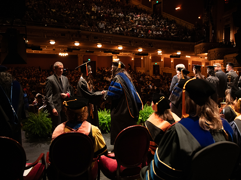 Graduate Students Walking across the Stage.