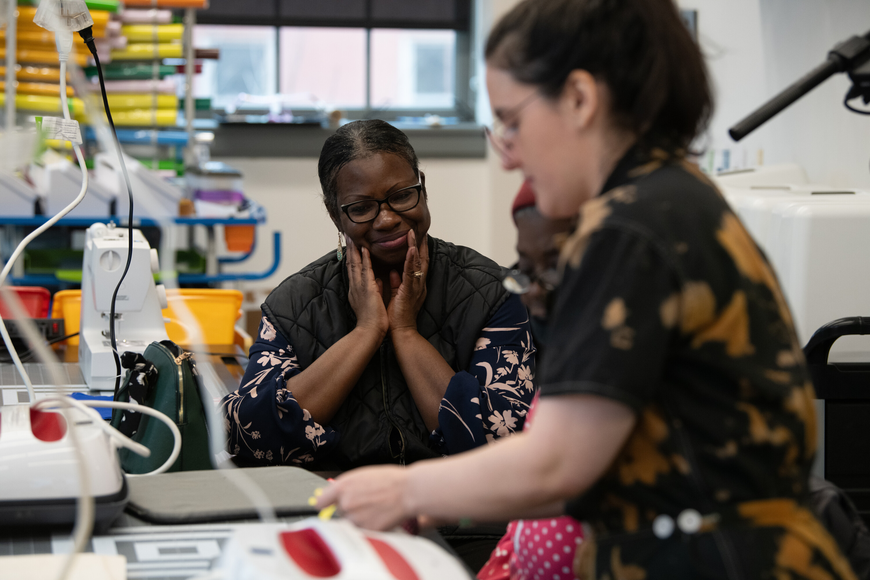 a person instructing another person how to sew
