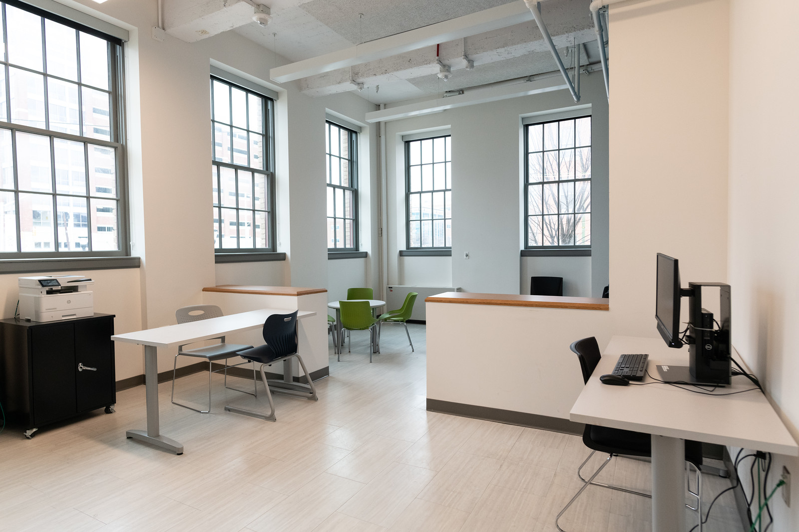 brightly lit office space with computer and chairs