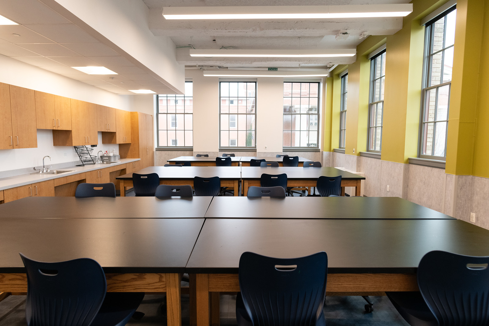 brightly lit classroom with lab tables and chairs