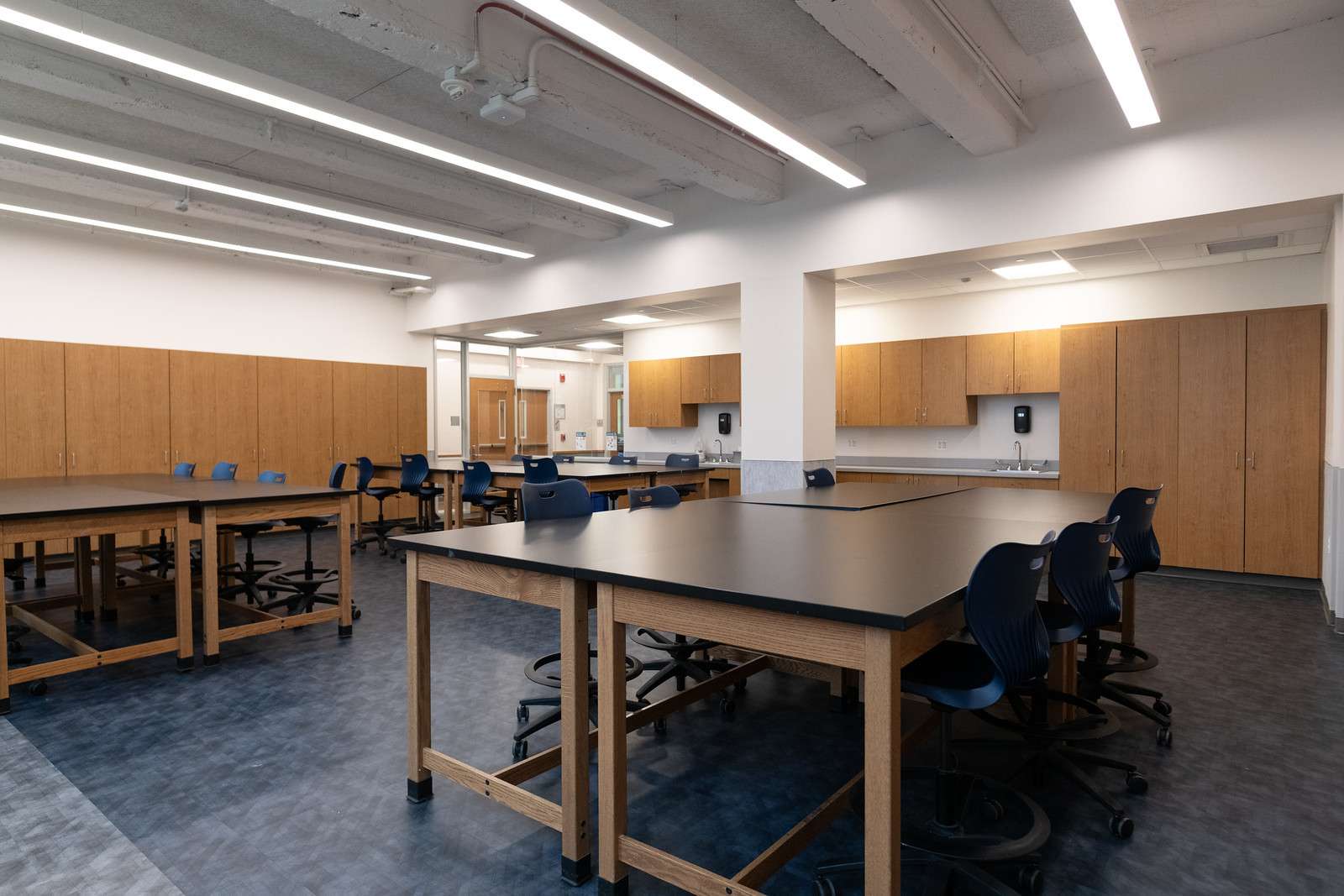 brightly lit classroom with lab tables and chairs