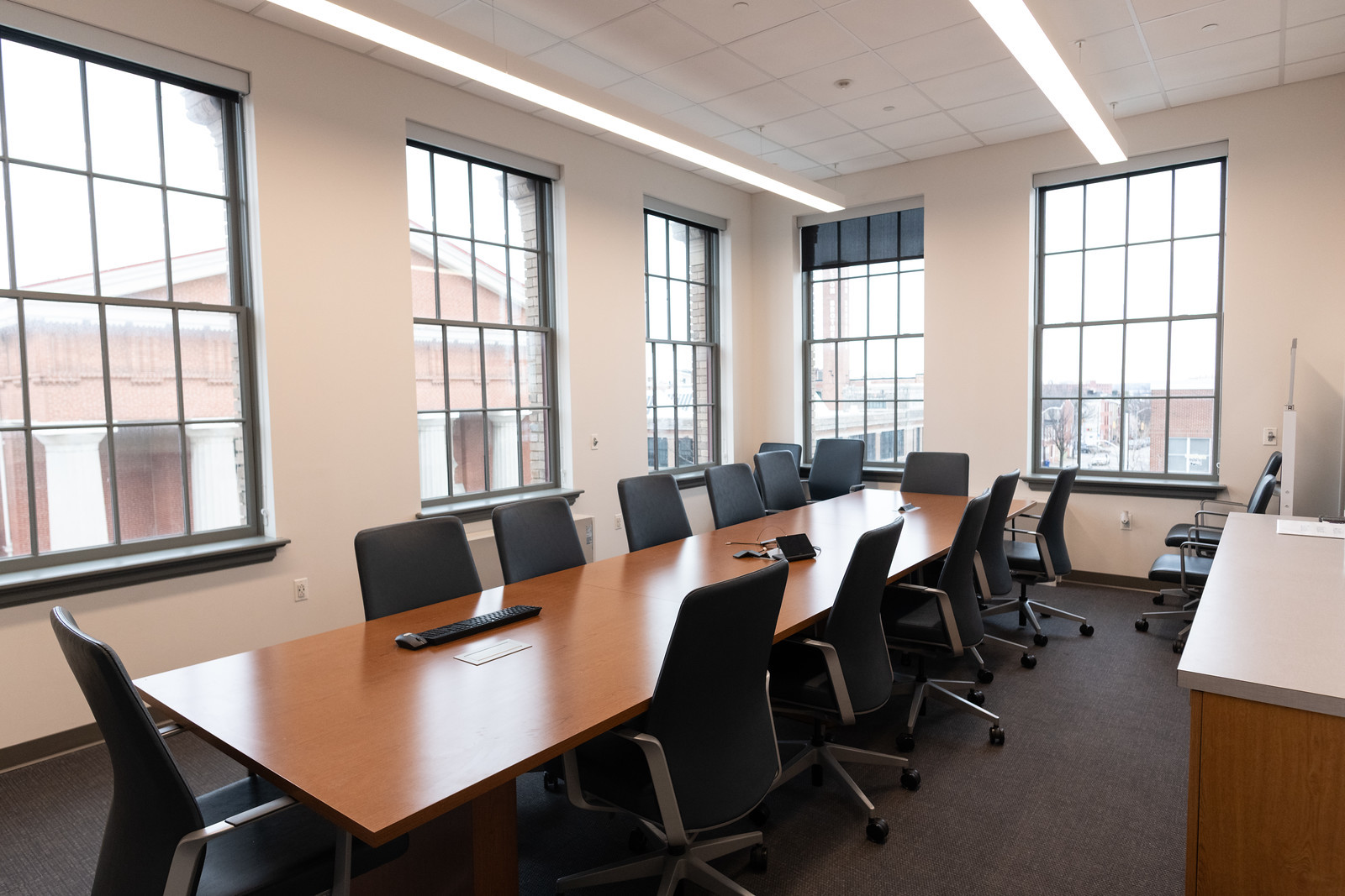 brightly lit conference room with chairs surrounding a large table