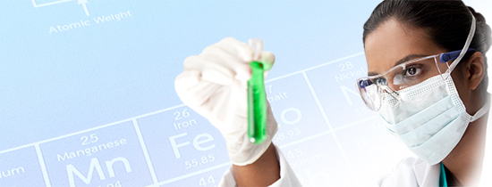 Researcher holding a test tube, with a portion of the periodic table visible as a background