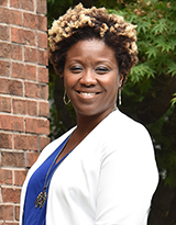 Portrait of Cherita Adams in a white blazer and blue shirt