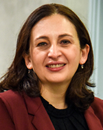 Portrait of Patty Alvarez wearing a black shirt with a maroon blazer