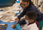 Dental student Shayla Butler assists UMB CURE Scholar Mohamed Kounet