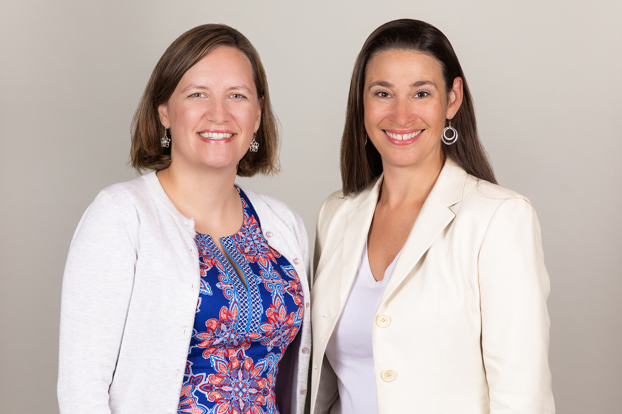 Two women next to each other with white background