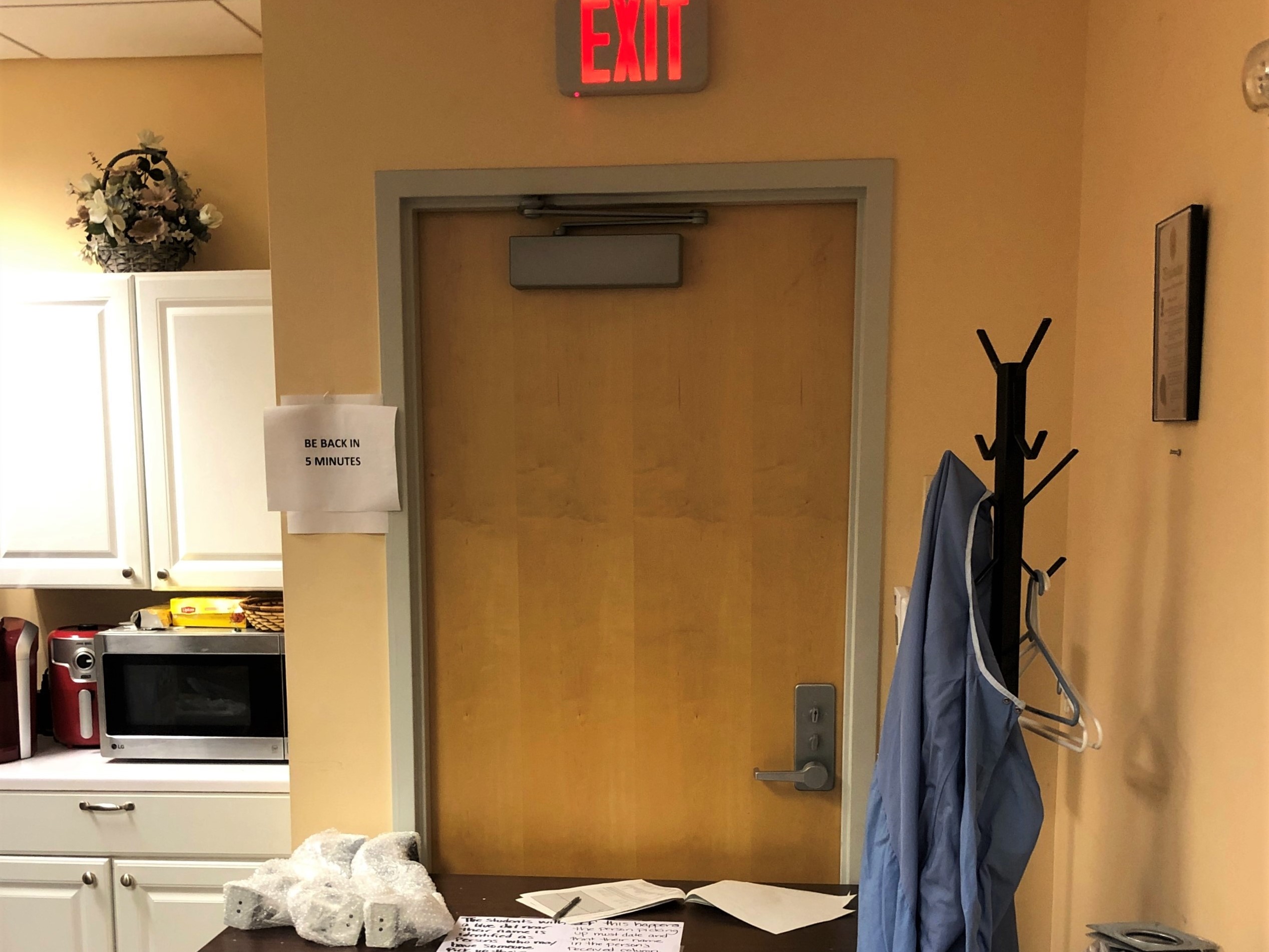 A table blocking a door marked as an exit.