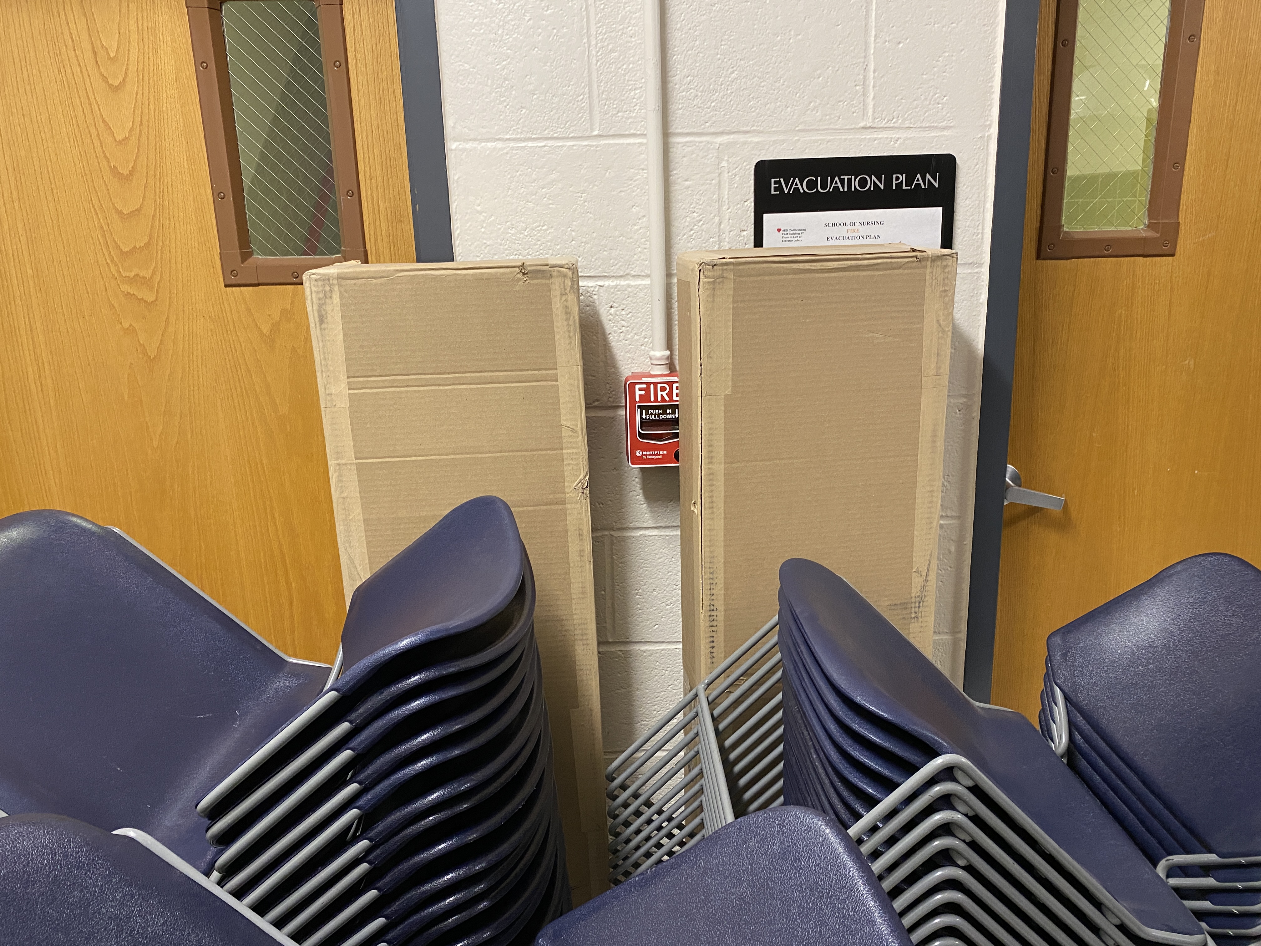 A manual pull station obstructed by boxes.