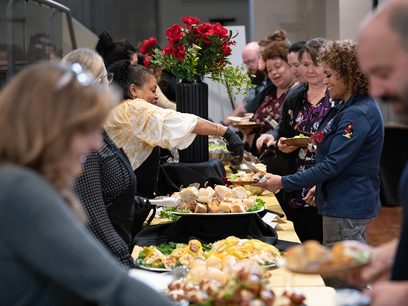 Group of staff being served lunch by UMB Employees