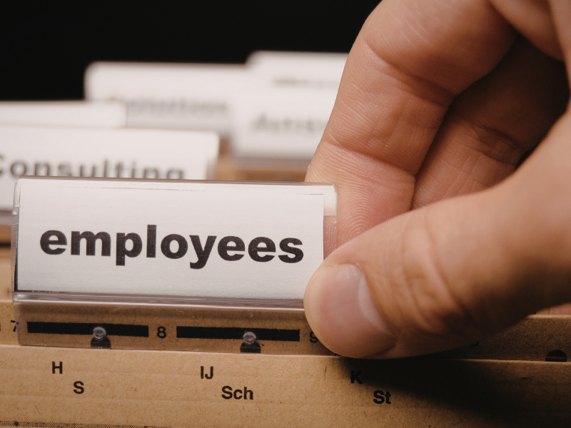 A hand grabs a tabbed folder labeled Employees