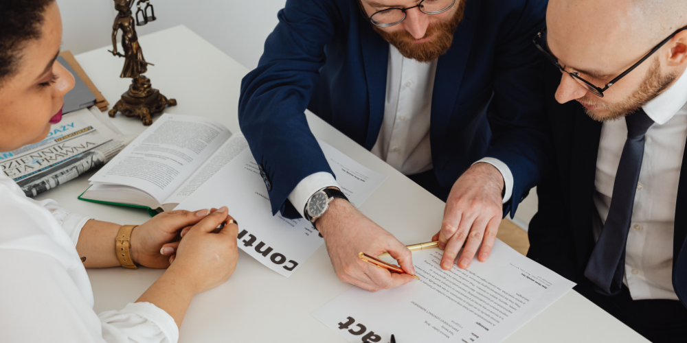Three people look over a contract.