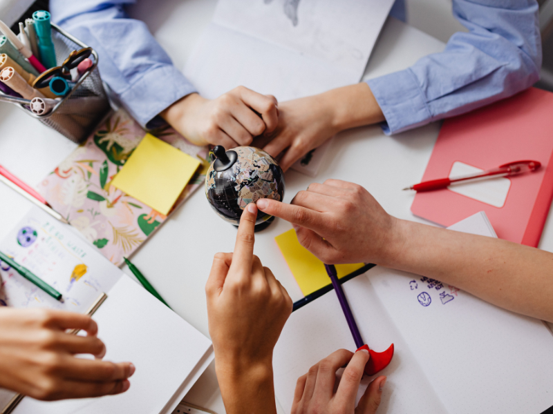 Hands on a desk connecting on a small globe